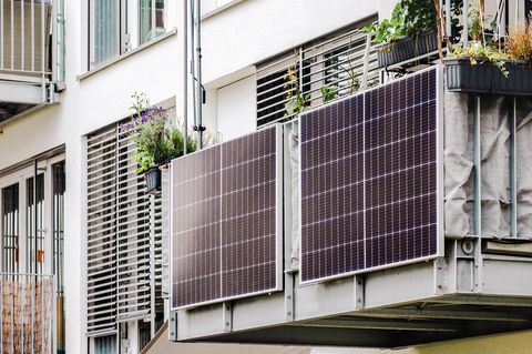 Balkonkraftwerk-Speicher kaufen: Zwei Solarmodule am Balkongeländer eines Mehrfamilienhauses.
