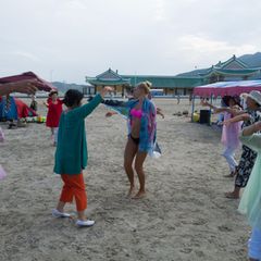 Nordkoreanerinnen laden die Touristinnen aus Russland zum Tanz. Die Reisegruppe ist entweder gemeinsam am Strand - oder im Hotel. Die Zelte sollen vor der Sonne schützen, koreanische Sommer sind heiß und schwül