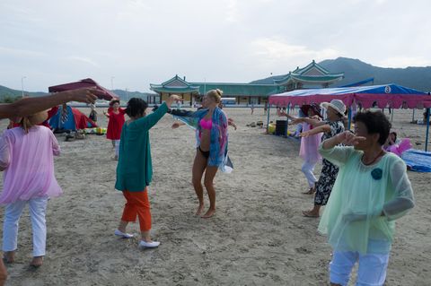 Nordkoreanerinnen laden die Touristinnen aus Russland zum Tanz. Die Reisegruppe ist entweder gemeinsam am Strand - oder im Hotel. Die Zelte sollen vor der Sonne schützen, koreanische Sommer sind heiß und schwül