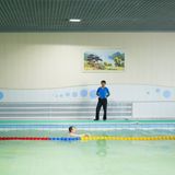 Mann schwimmt einsam in Swimmingpool