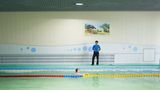 Mann schwimmt einsam in Swimmingpool