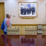 Eine Frau begutachtet zwei an der Wand hängende Fotos von Kim Jong-un
