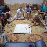 Russen sitzen auf dem Boden und spielen ein Brettspiel