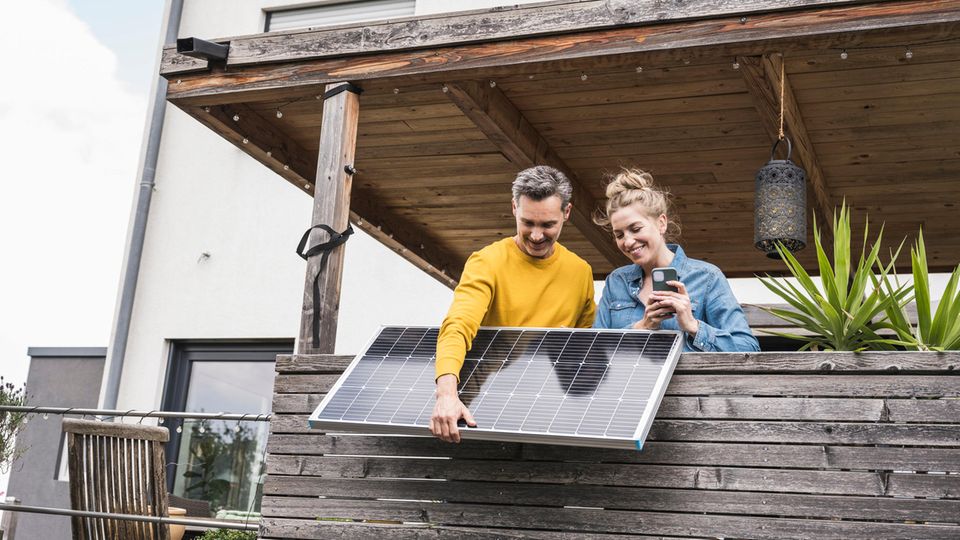 Junges Paar installiert Balkonkraftwerk auf Terrasse