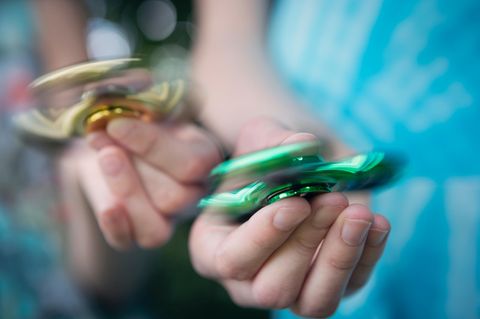 Zwei Hände mit Fidget Spinnern in der Hand