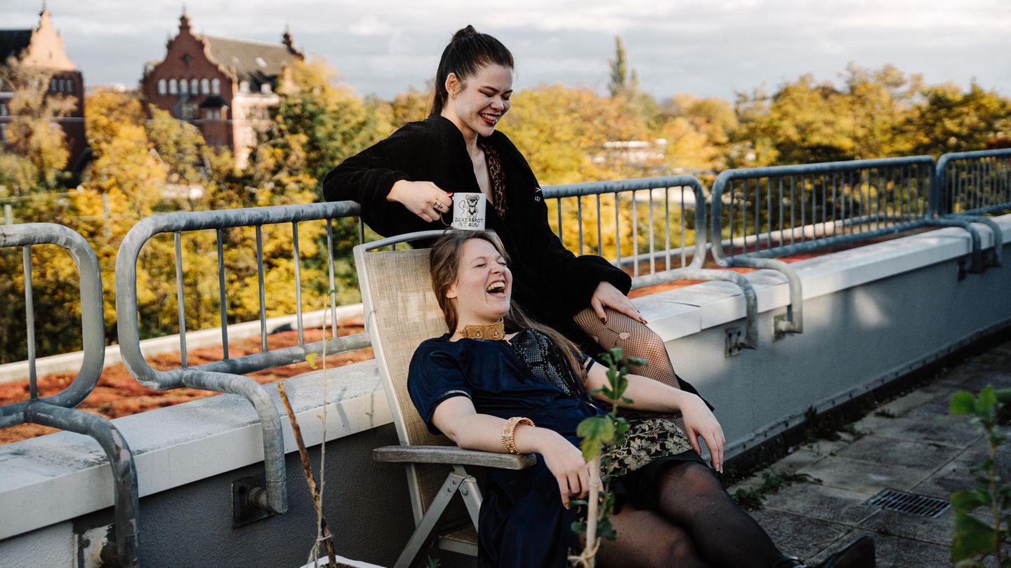 Entspannter Moment mit Blick über die Stadt: Mistress Cohbra und Raphaela Morning bei einer Pause auf der Terrasse