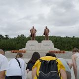 Sich verbeugende Touristen vor 2 Statuen in Nordkorea