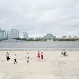 Nur ein Radfahrer ist unterwegs, als die russischen Touristen aus der Ferne auf den Kim Il-sung-Platz blicken: Der liegt auf der anderen Seite des Flusses. Unter dem aktuellen Diktator Kim Jong-un erlebte die Hauptstadt einen regelrechten Bauboom. Die meisten Nordkoreaner leben jedoch in bitterer Armut 