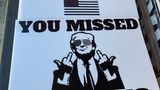 Wahlkampfschild mit stinkefingerzeigendem Trump