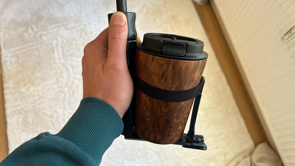 One hand holds the cupbrella containing a drink