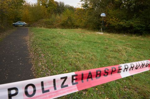 Ein Flatterband mit "Polizeiabsperrung" versperrt den Zugang zu einem Feldweg in der Eifel