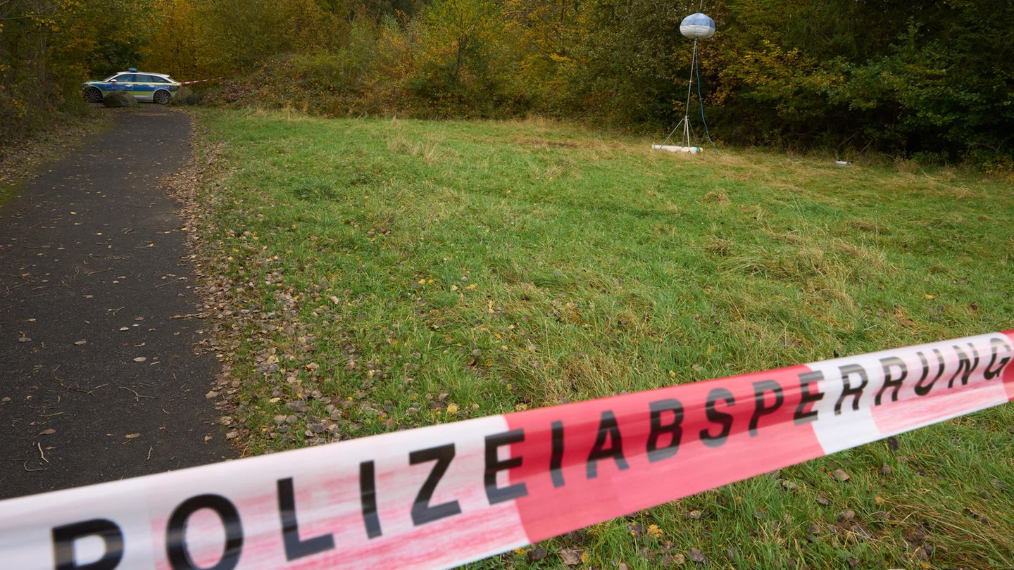Ein Flatterband mit "Polizeiabsperrung" versperrt den Zugang zu einem Feldweg in der Eifel
