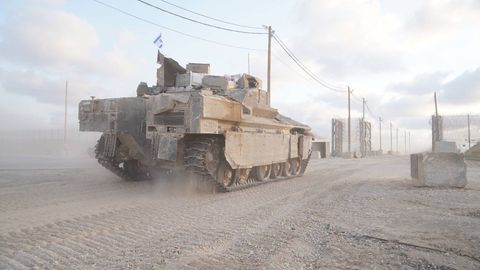 Ein Panzer der Armee von Israel befährt eine staubige Straße in Gaza