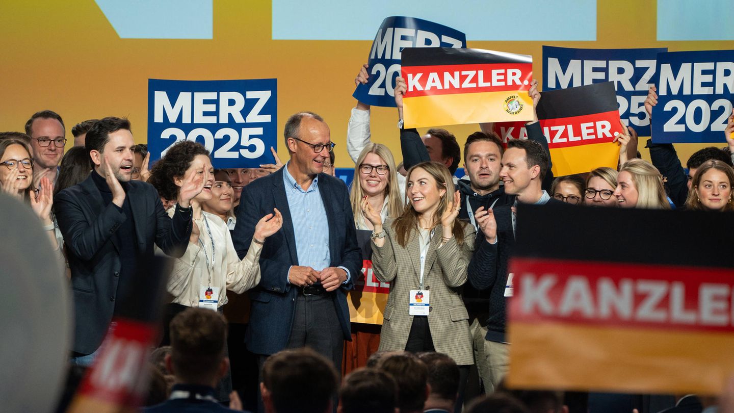 Auf dem Bild steht Friedrich Merz zwischen Mitgliedern der Jungen Union