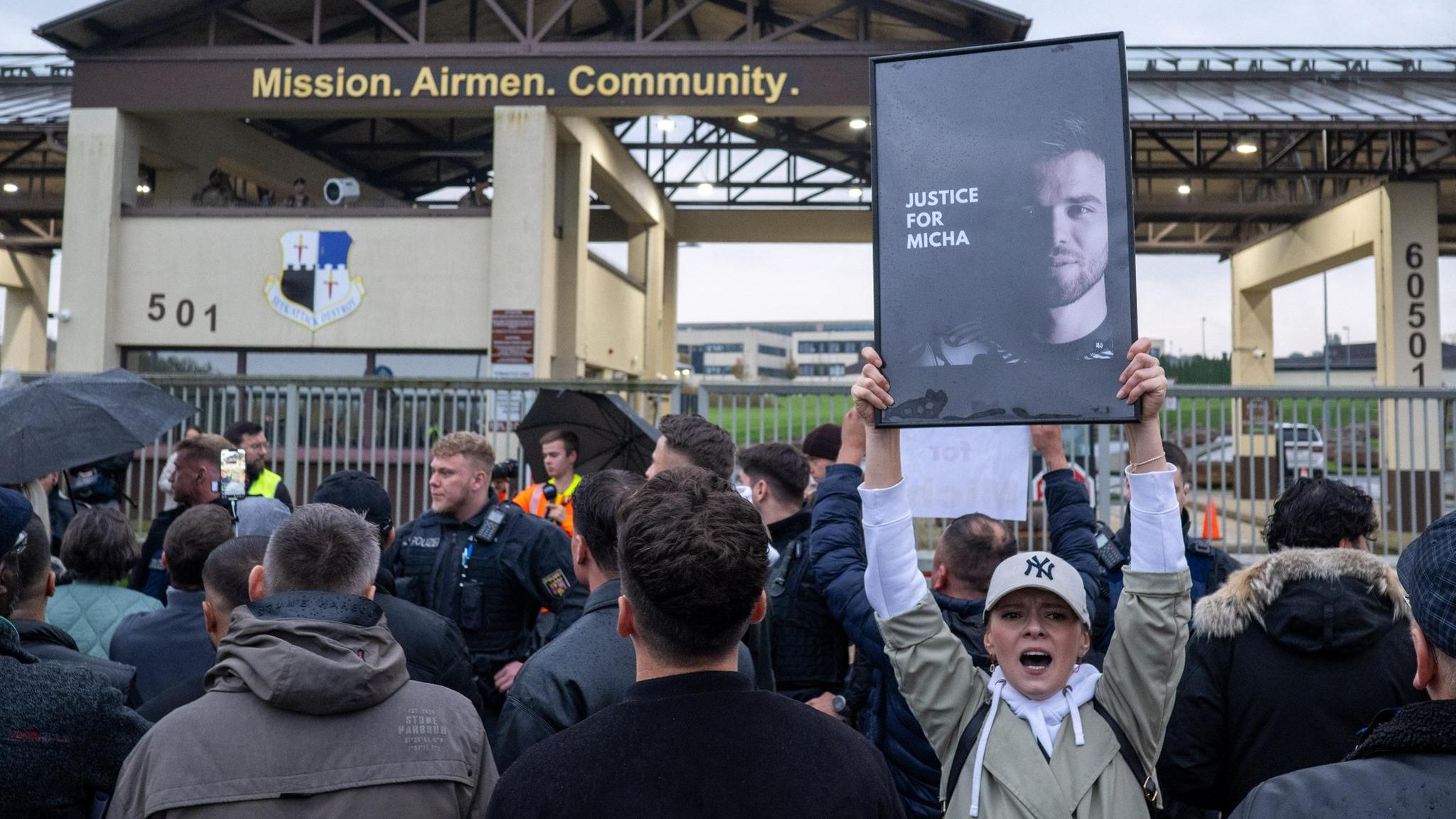 Demonstranten vor der Airbase halten Schilder hoch
