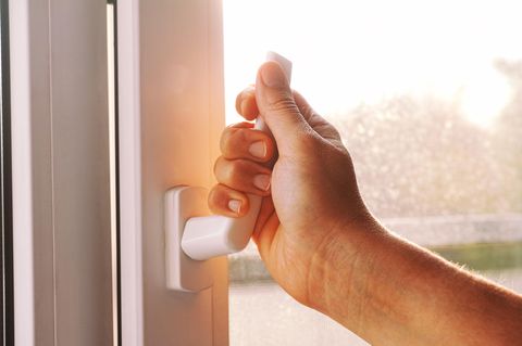 Frau öffnet Fenster zum Lüften