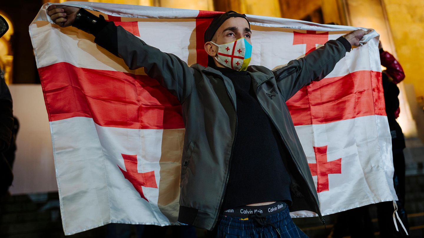 Georgien: Ein Demonstrant reckt die georgische Flagge in die Höhe