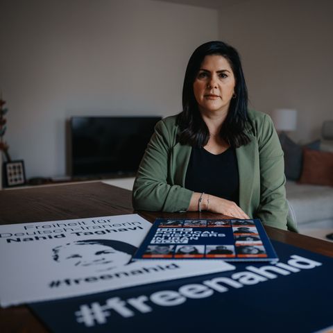Mariam Claren vor einem Plakat, das zur Befreiung ihrer Mutter aufruft