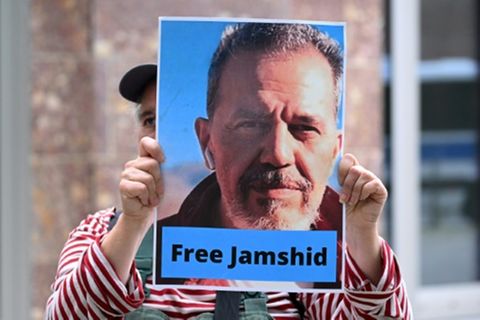 Demonstrant mit Plakat von inhaftiertem Jamshid Sharmahd