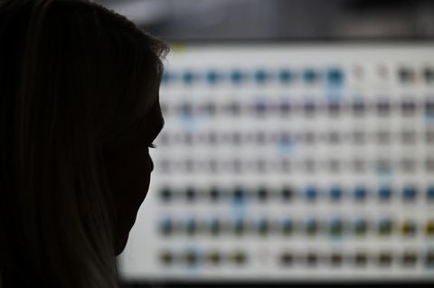 Eine Frau betrachtet auf einem Computermonitor Fotos von Missbrauchsopfern