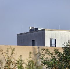 Das Gebäude der JVA Gablingen, man sieht eine Kamera und blauen Himmel