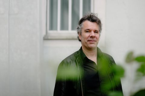 Der Jurist Thomas Galli steht vor einer Wand der JVA Tegel in Berlin