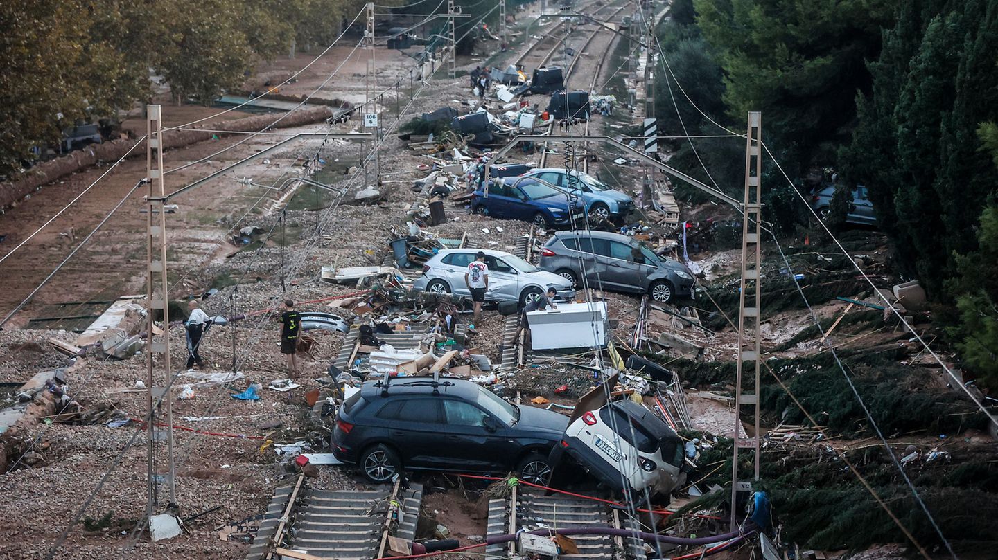 In Valencia stehen Autos, die durch das heftige Unwetter weggeschwemmt wurden, auf den Gleisen.