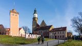 In Kamenz steht ein Kirchturm und der Name der Stadt als Skulptur. Die Zufriedenheit ist niedrig in Städten wie Kamenz.