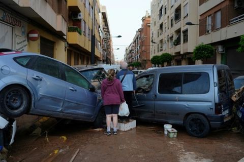 Bewohner vor aufgetürmten Autos in Valencia