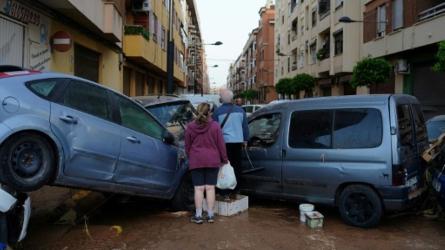 Bewohner vor aufgetürmten Autos in Valencia