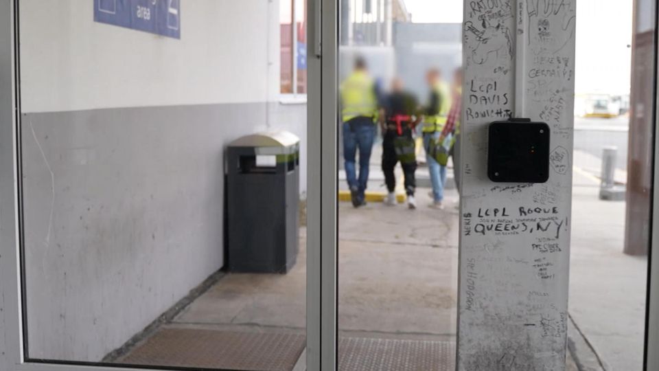 Ein Mann wird von den Einsatzkräften zum Flugzeug begleitet