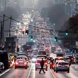 Auf einer befahrenen Straße in Berlin geht ein Mann über die Straße. Hier ist die Zufriedenheit mittelmäßig.