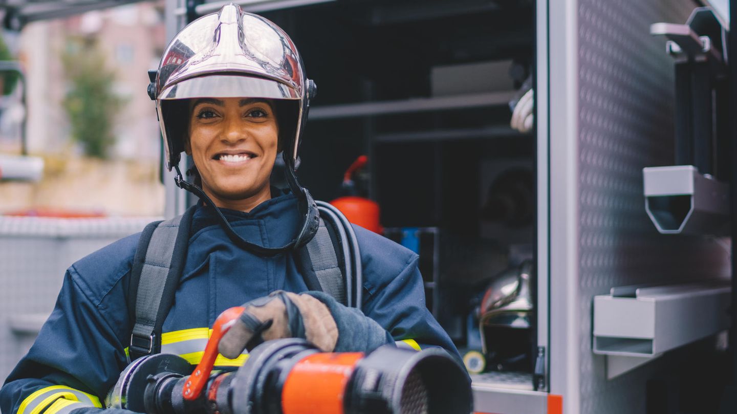 Eine Feuerwehrfrau mit Schlauch in den Händen
