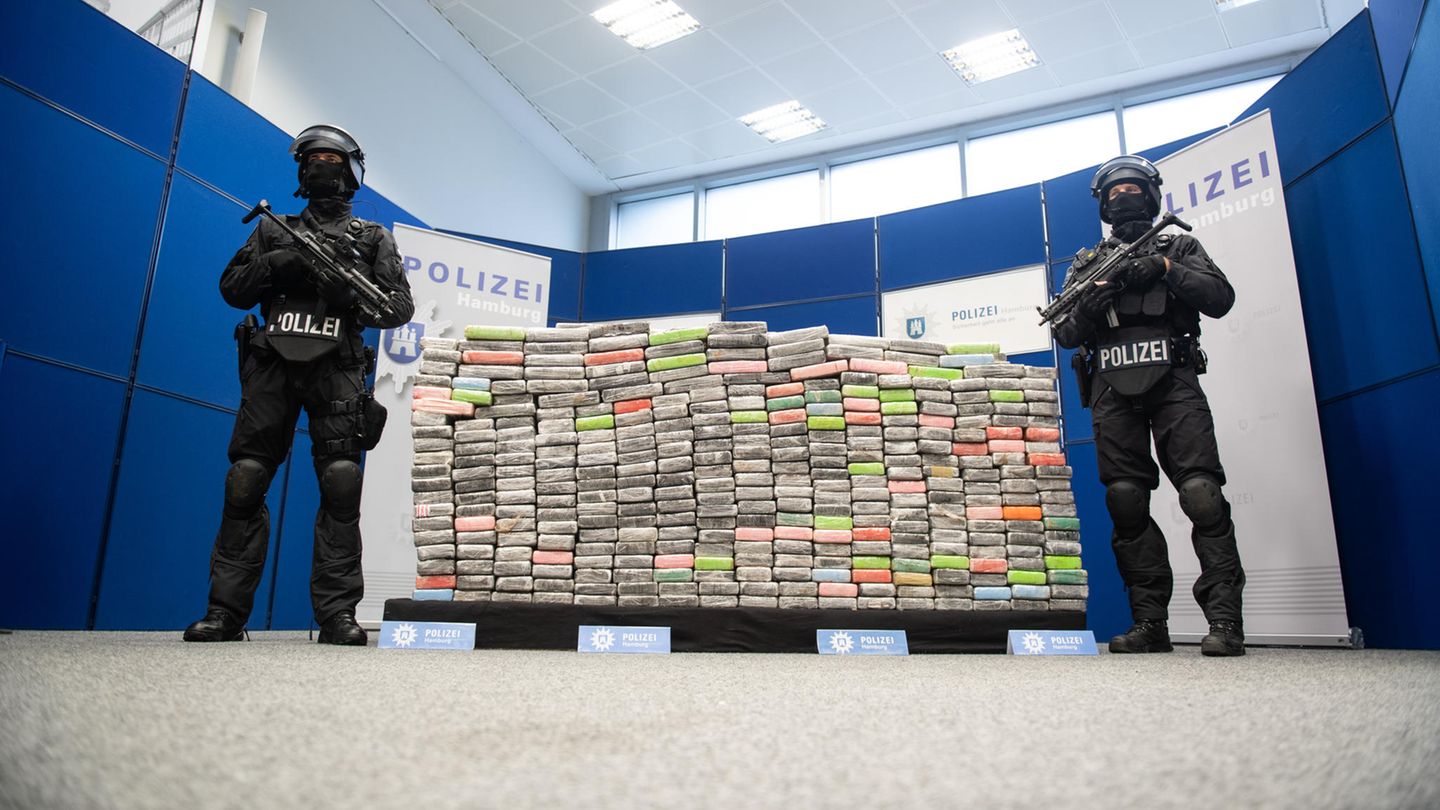 Zwei schwer bewaffnete Polizisten vor 2,1 Tonnen sichergestelltem Kokain
