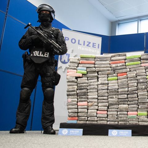 Zwei schwer bewaffnete Polizisten vor 2,1 Tonnen sichergestelltem Kokain