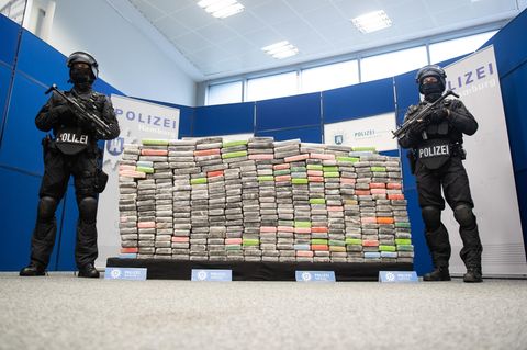 Zwei schwer bewaffnete Polizisten vor 2,1 Tonnen sichergestelltem Kokain