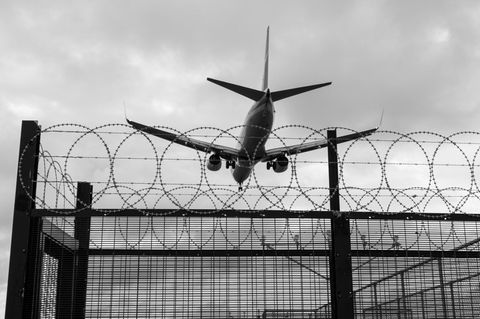 Abschiebung (Symbolbild): Ein Flugzeug fliegt über Stacheldraht