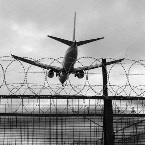 Deportation (symbolic image): A plane flies over barbed wire