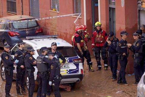 Polizisten stehen in den schlammigen Wassermassen in Spaniens Katastrophengebiet