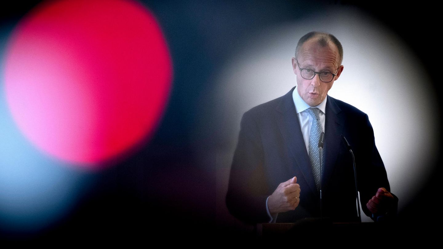 Zu sehen ist Friedrich Merz durch eine Kamerlinse während einer Rede
