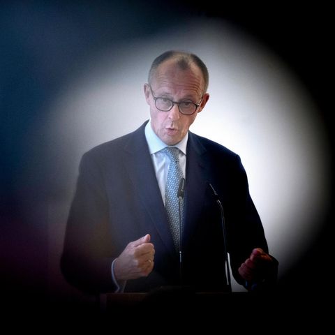 Friedrich Merz can be seen through a camera lens during a speech