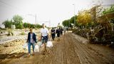 Menschen tragen Lebensmittel in einem von den Fluten betroffenen Gebieten