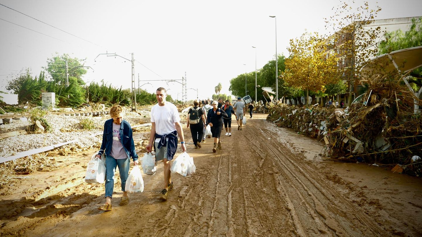 Menschen tragen Lebensmittel in einem von den Fluten betroffenen Gebieten Menschen tragen Lebensmittel in einem von den Fluten betroffenen Gebieten