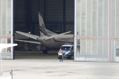 Abschiebung: Ein Flugzeug startet - fotografiert durch Stacheldraht