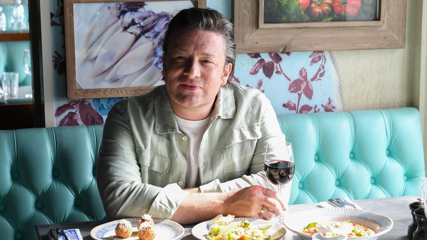 Portrait Jamie Oliver in einem Restaurant mit unterschiedlichen speisen auf dem Tisch