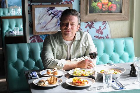 Portrait Jamie Oliver in einem Restaurant mit unterschiedlichen speisen auf dem Tisch
