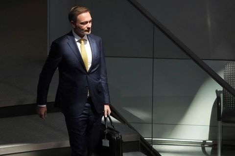 Christian Lindner geht mit einem Aktenkoffer eine Treppe hinunter