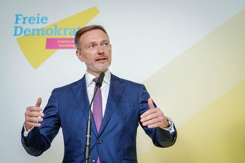 Christian Lindner hält auf einer Bühne mit Logo der FDP eine Rede