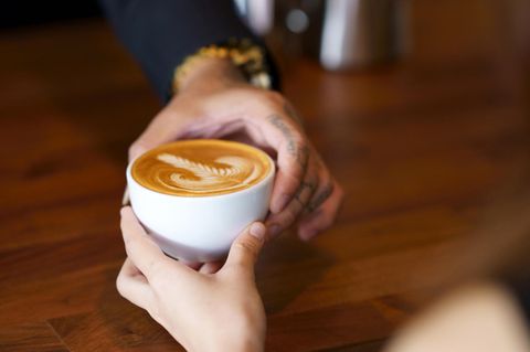 Barista-Kaffee wird von Hand zu Hand gereicht