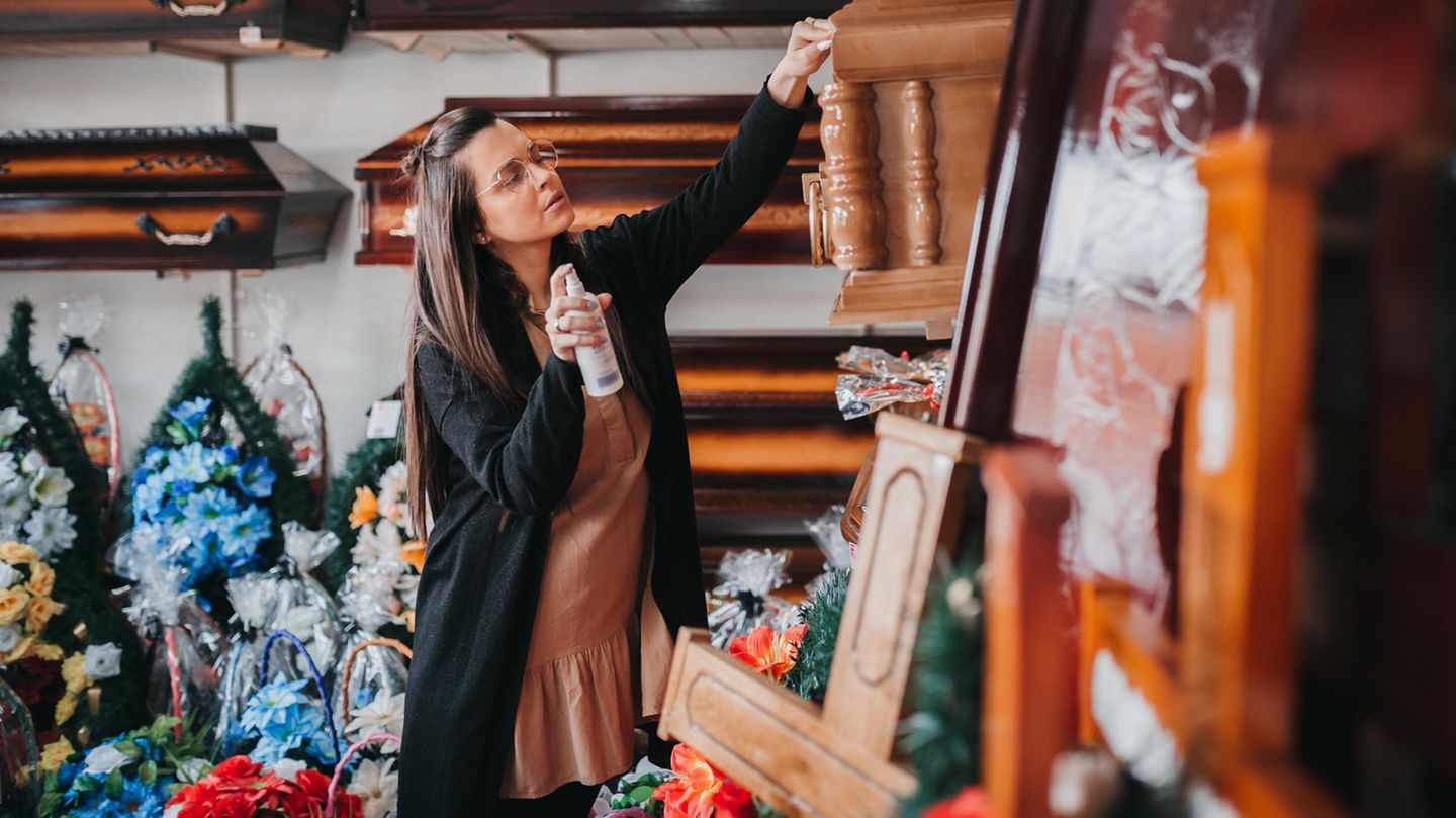 Geld verdienen mit Bestattungen Eine Frau zeigt ein Foto, um einen Sarg zu verkaufen und Geld zu verdienen
